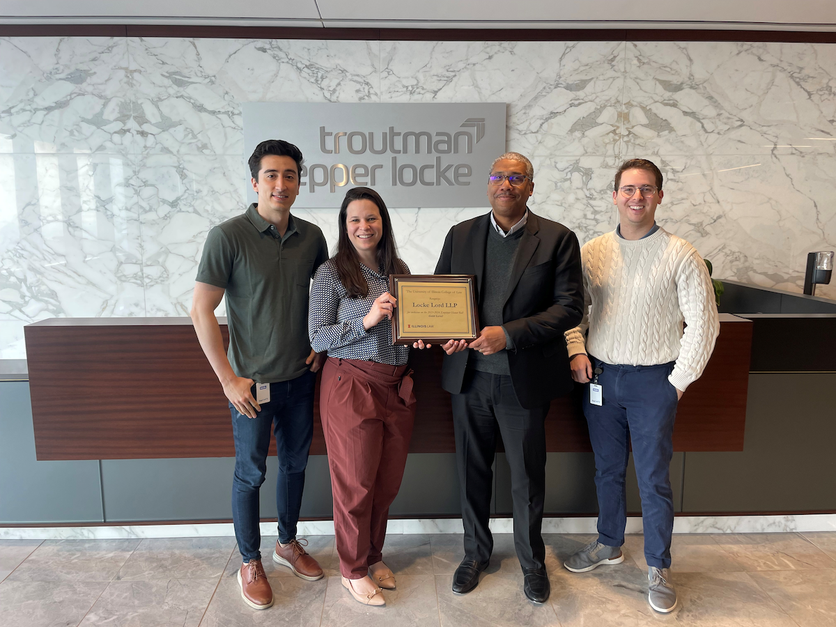 Dean Jamelle Sharpe presents a plaque to alumni at Troutman Pepper Locke