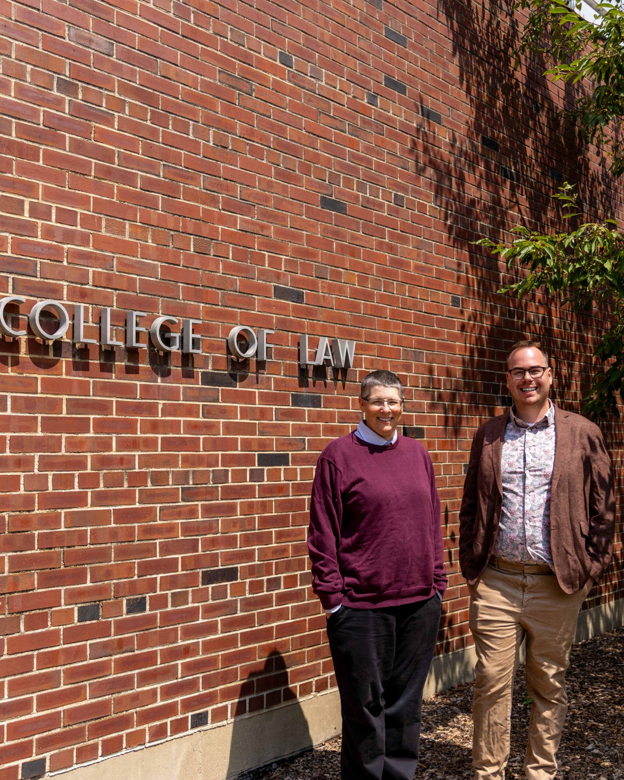 Sarah Lawsky and Eric Baudry stand outside the College of Law Building